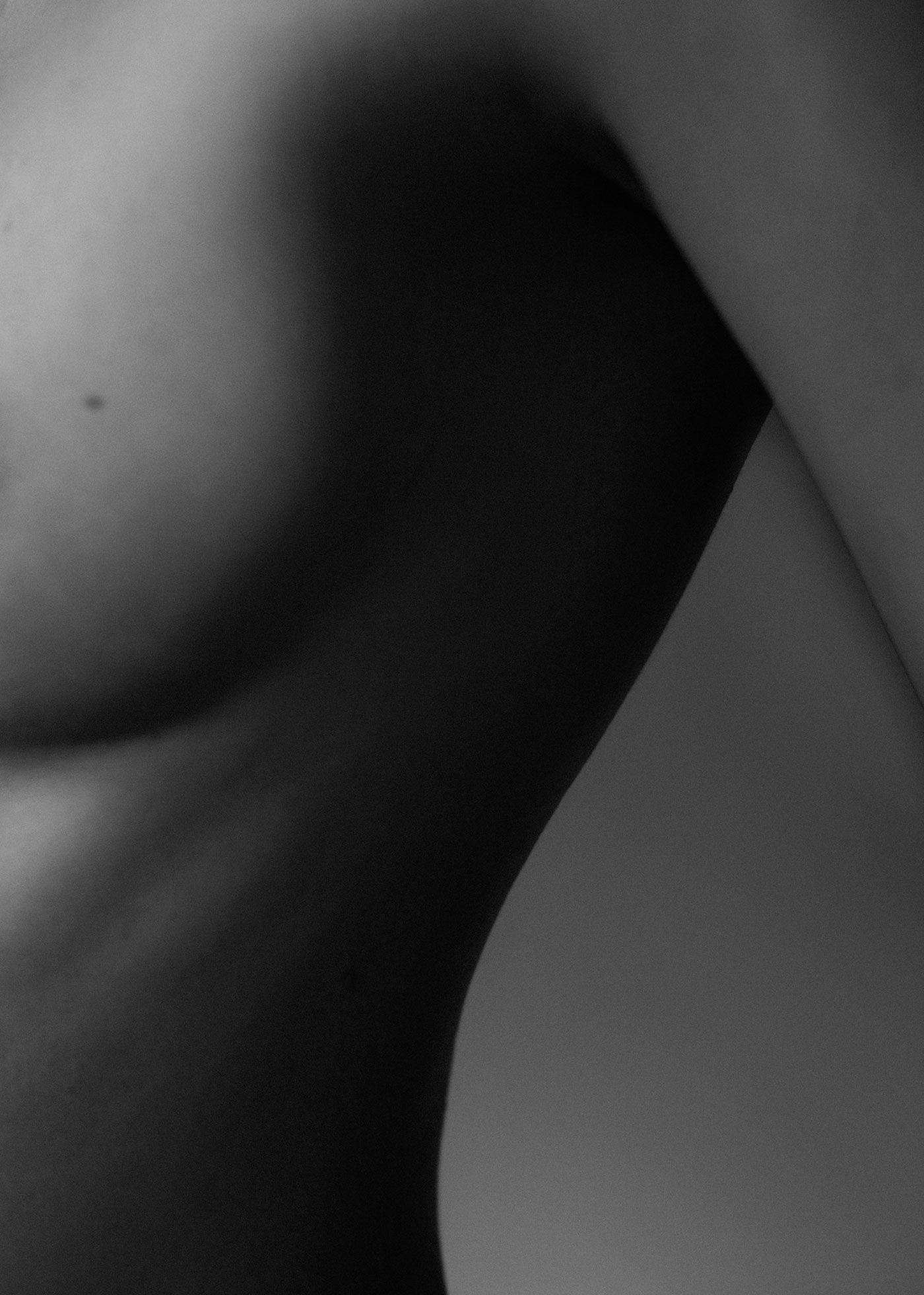 Schwarz-weiß Foto einer nackten Brust und einer sportlichen Taille einer schönen, jungen Frau im Halbseitenprofil - auf der Seite "Leistungsspektrum" von www.hanseatic-facelift.de unter der Rubrik "Brustvergrößerung mit Eigenfett" - "Eine Methode, die in ausgewählten Fällen angewendet werden kann, ist die Vergrößerung durch Injektion von Eigenfett in die Brust – nach Entnahme aus Bereichen, in denen Überschüsse vorhanden sind. Es sind oft mehrere Sitzungen erforderlich, bis das gewünschte Volumen erreicht ist. Lipotransfer, Lipoimplantat oder Lipofilling der Brust ermöglicht es, das Volumen der Brust mit dem Fett der Patientin aus anderen Körperbereichen zu vergrößern, ohne Silikonprothesen verwenden zu müssen. Für die Brustvergrößerung mit Eigenfett wird Ihr eigenes Fett aus Spendebereichen – meist Hüften, Beine oder Bauch – entnommen, in einer Zentrifuge aufbereitet und dann mit einer kleinen Kanüle transplantiert. Der Eingriff dient der natürlichen Vergrößerung der Brust und eignet sich besonders zur Brustrekonstruktion, als ergänzende Methode zur Behebung von Unregelmäßigkeiten in einer rekonstruierten Brust sowie zur Vorbereitung der Haut nach einer Strahlentherapie".